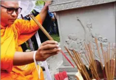  ?? PHA LINA ?? A monk lights incense at a ceremony marking the 13th anniversar­y of the death of Chea Vichea in Phnom Penh yesterday.