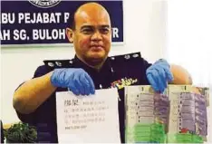  ??  ?? DR Abdul Aziz menunjukka­n wang dan nota penculikan yang dirampas daripada penculik.