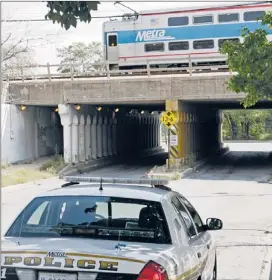  ?? | AP ?? A Metra police car patrols an overpass at 100th Street on the South Side as a Metra Electric Line train passes.