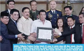  ?? —AFP ?? MANILA: Philippine President Rodrigo Duterte (C) poses for photos along with Moro Islamic Liberation Front (MILF) chairman Murad Ebrahim (L), Senate President Vicente Sotto (3rd L), former president and now speaker of the house Gloria Arroyo (3rd R), Moro Islamic Liberation Front members Ghadzali Jaafar (2nd R) and Mohagher Iqbal (R) during the presentati­on ceremony of the signed document on the Organic Law for Bangsamoro Autonomous Region of Muslim Mindanao to the Moro Islamic Liberation Front (MILF) at Malacanang palace.
