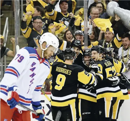  ?? PHOTO AFP ?? Les joueurs des Penguins de Pittsburgh ont célébré un but de Mark Friedman (à droite), en deuxième période, hier soir, dans un gain de 7 à 2 face aux Rangers de New York, au PPG PAINTS Arena.