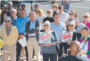  ??  ?? Businessme­n Shane O'Connor and Max Christmas with David Cash from Wilson Parking as crowd members sign petitions and protesters listen to speeches.