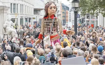  ?? TOLGA AKMEN/AGENCE FRANCE-PRESSE ?? ‘LITTLE Amal,’ a giant puppet depicting a Syrian refugee girl, makes her way to St. Paul’s Cathedral in the City of London on Saturday as part of the internatio­nal art project The Walk. It has made an 8000-km journey across Europe to the United Kingdom to raise awareness of the challenges faced by refugee children.