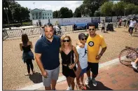  ?? AP/MANUEL BALCE CENETA ?? People pose for photos last week in front of the White House, which recently put up a tall wooden barrier for a project to replace the fence that surrounds the property.