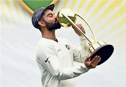  ?? AFP ?? Skipper Virat Kohli kisses the Border-Gavaskar trophy after India won the Test series against home team Australia. —