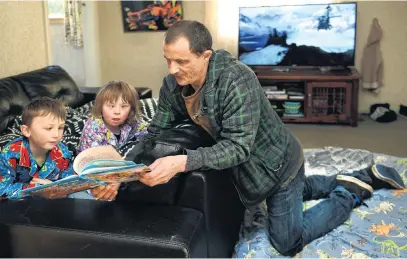  ?? PHOTO: STEPHEN JAQUIERY ?? Story time . . . Parent Brendan Selwood reads to his children Alex (6) and Emily (8) at their Brighton home, in which they all sleep in the lounge.