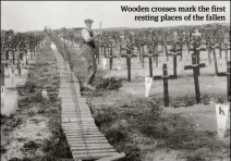  ??  ?? Wooden crosses mark the first resting places of the fallen