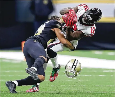  ?? PHOTOS BY CURTIS COMPTON / CCOMPTON@AJC.COM ?? Saints cornerback Marshon Lattimore loses his helmet but brings down Falcons receiver Mohamed Sanu during the third quarter. Sanu finished with four catches for 31 yards. The Falcons totaled 288 yards passing but were hurt by mistakes.