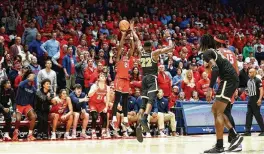  ?? ?? Kobe Elvis makes a game-tying 3-pointer in the final minutes of overtime against VCU on Friday at UD Arena. “I don’t get too low when everybody’s on me,” Elvis said, “and I don’t get too high on a night like this either.”