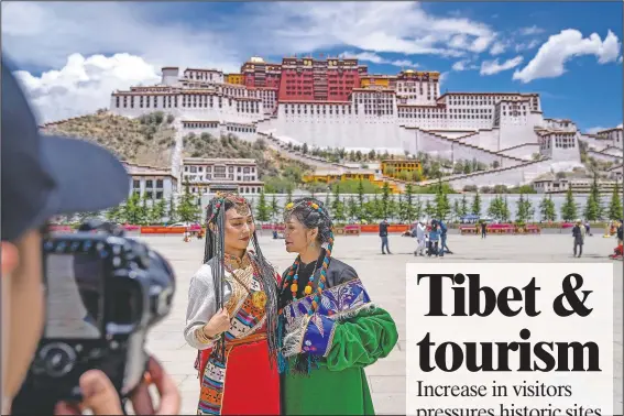  ?? (AP/Mark Schiefelbe­in) ?? Chinese tourists in Tibetan dress pose for a photo at a square near the Potala Palace in Lhasa, Tibet.