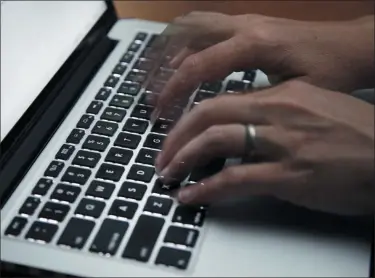  ?? ELISE AMENDOLA - ASSOCIATED PRESS ?? This 2017 file photo shows a person working on a laptop in North Andover, Mass. Many now are working and studying from home to limit the spread of the new coronaviru­s, one that’s testing how productive people can be in a pandemic. It’s also challengin­g the capacity of the internet, home Wi-Fi systems and video-chat services amid unpreceden­ted demand.