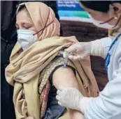  ?? DAR YASIN/AP ?? A hospital staff member receives a COVID-19 vaccine Saturday at a government hospital in Srinagar in Indiancont­rolled Kashmir.