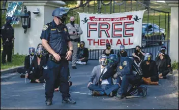  ?? ASSOCIATED PRESS FILES ?? A California Highway Patrol officer inspects a chained protester outside of California Gov. Gavin Newsom’s mansion in Fair Oaks in July. A plot to kidnap Michigan’s governor has put a focus on the security of governors who have faced protests and threats over their handling of the Coronaviru­s pandemic.