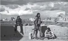  ?? AP PHOTO/FELIPE DANA ?? U.S.-backed Syrian Democratic Forces fighters stand in an area recently taken by SDF as the fight against Islamic State militants continued Sunday in the village of Baghouz, Syria. Islamic State militants are preventing more than 1,000 civilians from leaving a tiny area still held by the extremist group in a village in eastern Syria.