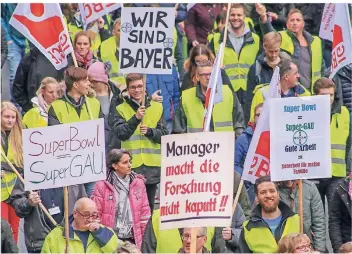  ?? FOTO: IMAGO ?? Bayer-Mitarbeite­r demonstrie­ren in Wuppertal: „Hauptsache Mon(ey)santo“und „Super Bowl gleich Super-Gau“steht auf den Plakaten.