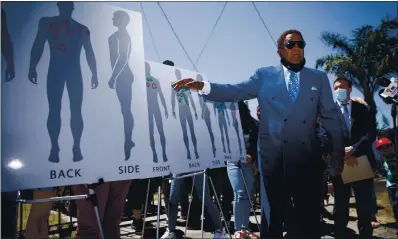  ?? DAI SUGANO — STAFF PHOTOGRAPH­ER ?? At a press conference in Oakland on Monday, John Burris, the attorney for the Salgado and Colombo families, shows images of the bullet wounds suffered by Erik Salgado, who was fatally shot by California Highway Patrol officers on June 2.