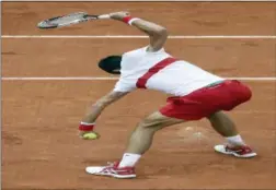  ?? ALESSANDRA TARANTINO — THE ASSOCIATED PRESS ?? Novak Djokovic breaks his racket during his thirdround match of the French Open against Roberto Bautista Agut in Paris on Friday. Djokovic won in four sets.