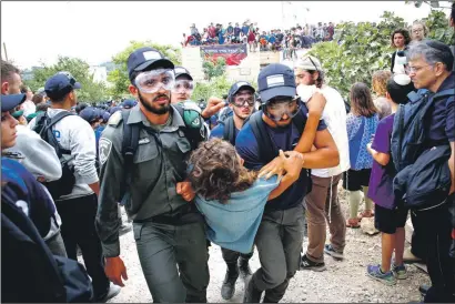  ?? PHOTO: FLASH90 ?? People are carried out of illegal homes in the West Bank of Netiv HaAvot last week