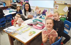  ?? NEWS PHOTO TIM KALINOWSKI ?? Webster Niblock Grade 1 teacher Danielle Beach has organized the school's annual Christmas Canadian Tire money drive for the past 19 years, and is hoping to beat the record of $2,000 raised last year. Pictured at the table clockwise: Teacher Danielle...