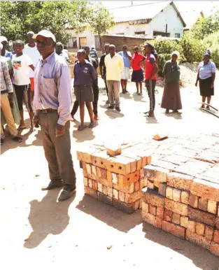  ??  ?? ABOVE: A curious crowd gather around after Sekuru Chikodzore was caught stealing bricks from a nearby school.