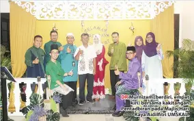  ??  ?? DR Murnizam (berdiri, empat kiri) bersama kakitangan Pentadbira­n pada Majlis Hari Raya Aidilfitri UMSKAL.