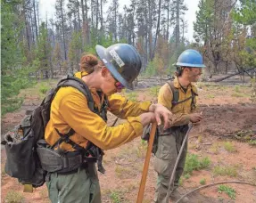  ?? CHRIS PIETSCH/USA TODAY NETWORK ?? Brentt Call, left, and Mike Poulos, with Utah Taskforce One, take a break on the Bootleg Fire east of Klamath Falls. Ore., last year.