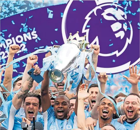  ?? ?? TOP OF THE WORLD: Fernandinh­o lifts the Premier League trophy as the Manchester City players celebrate their title victory last month.