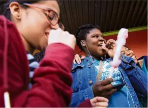  ??  ?? Two teenagers enjoying some free cotton candy at the festival organised by Overtown Youth Center.