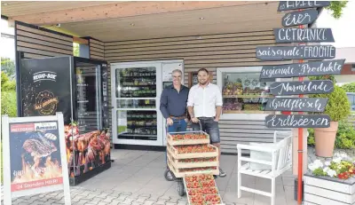  ?? FOTO:PR ?? Tobias und Andreas Kolb vor ihren 24-Stunden-Automaten in Meckenbeur­en. Hier gibt es auch selbstgema­chte Marmelade.