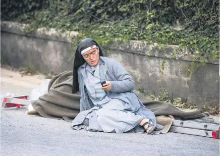  ?? Picture / AP ?? Sister Marjana Lleshi says she was texting family and friends in her native Albania to tell them that she was alive when she was photograph­ed.
