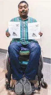  ?? SHAHRILL BASRI/THESUN ?? Jeyaraj showing the book Guidance for Wheelchair Bound, which he took three years to write.
