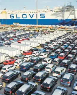  ?? FILE ?? Cars and trucks for export are parked at a port in China. COVID-19-triggered shutdowns of Chinese microchip plants have slowed new car production worldwide, leaving dealers with fewer cars to sell and boosting prices of used cars.