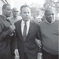  ?? WILFREDO LEE AP ?? Suspended Broward County Sheriff Scott Israel, center, leaves a news conference surrounded by supporters Friday in Fort Lauderdale after Florida Gov. Ron DeSantis suspended him.