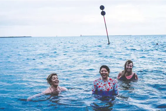  ?? PHOTOS: JAMES FORDE/THE WASHINGTON POST ?? Gillian Skully, left, Mia Skully and Patricia Penny of the Dollymount Dames take a dip outside Clontarf Yacht & Boat Club in County Dublin.