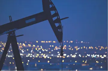  ??  ?? A pumpjack operates above an oil well at night in the Bakken Formation on the outskirts of Williston, North Dakota, on Mar 8. — WPBloomber­g photos