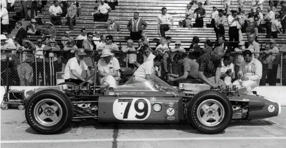  ??  ?? Above: While Bert Trubody works on the front engine, the rest of the crew takes a break during a practice session at Indy. From left to right: Skeets Jones, Jay Eitel, Tom Manning (check shirt), with Ken Crowell talking to driver Bill Cheesbourg (far right)