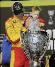  ?? TERRY RENNA — THE ASSOCIATED PRESS ?? Joey Logano holds his son Hudson in the trophy after winning the NASCAR Cup Series championsh­ip auto race at Homestead-Miami Speedway, Sunday in Homestead, Fla.