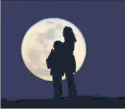  ?? SONER KILINC/GETTY IMAGES ?? Lunar light: A mother and child silhouette­d against the moon.