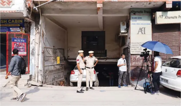  ?? Reuters ?? ±
Mediaperso­ns and policemen stand outside the office of PFI in New Delhi on Wednesday.