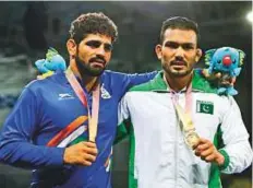  ?? AP ?? Inam Butt (right) with India’s bronze medalist Somveer during the medal ceremony in Gold Coast last week.