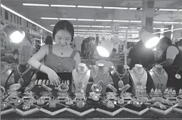  ?? BEIJING
-AP ?? A shopkeeper selling prayer beads sorts goods on display at a trade center in Wenhui Township, Hainan province. Processing of prayer beads has become the township's pillar industry.