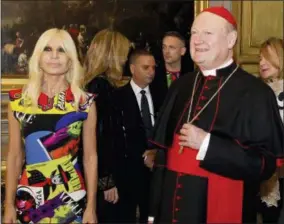  ?? DOMENICO STINELLIS — THE ASSOCIATED PRESS ?? Cardinal Gianfranco Ravasi and designer Donatella Versace arrive at Palazzo Colonna in Rome, Monday. The Vatican is loaning some of its most beautiful liturgical vestments, jeweled miter caps and historic papal tiaras for an upcoming exhibit on...