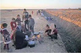  ?? FOTO: AP ?? Flüchtling­e vor den Kämpfen zwischen Regierungs­truppen und dem IS kampieren an einem Graben, der die Grenze zur Kurdenregi­on markiert.