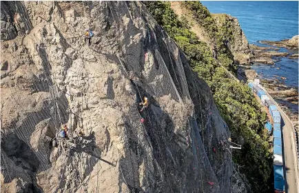  ?? PHOTO: DAVID WALKER/STUFF ?? Abseilers perched high above State Highway 1 south of Kaikoura, work at stabilisin­g slip sites with wire mesh.