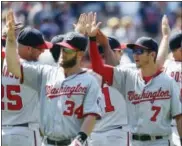  ?? RON SCHWANE — THE ASSOCIATED PRESS ?? Trea Turner (7) and Bryce Harper (34) celebrate with teammates after the Washington Nationals’ 4-1 win over the Cleveland Indians on Wednesday.