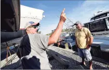  ?? Arnold Gold / Hearst Connecticu­t Media ?? Kevin Barosso, left, of Westbrook, and Chris Hales, of Waterbury, talk about the yacht Lady May at Harry's Marina in Westbrook Aug. 20. President Donald Trump’s former campaign strategist, Steve Bannon, was arrested on federal charges earlier in the day from that yacht off the coast of Westbrook.