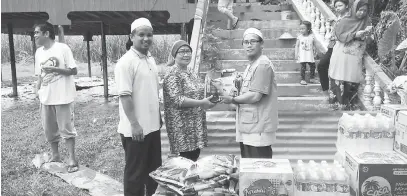  ??  ?? KEPERLUAN MENDESAK: Wakil PAS menyerahka­n sumbangan makanan kepada mangsa banjir.