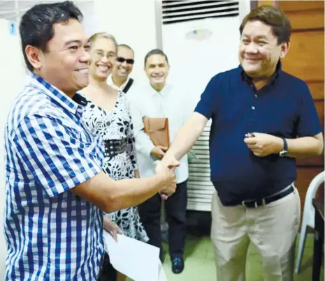  ?? (SUN.STAR FILE) ?? FORESHADOW­ING? Last August, Jonathan Guardo (left) shook hands with Rep. Tomas Osmeña before Philippine Mediation Center mediator Marissa Puche and lawyers Ferdinand Cañete (in dark glasses) and Ralph Sevilla, ending years of enmity between the former...