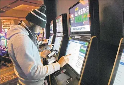  ?? KIM HAIRSTON/BALTIMORE SUN ?? Sean Tyler places bets at one of the self service terminals in the Sports & Social Maryland bar, restaurant and gaming venue as The FanDuel Sportsbook launches sports betting at Live! Casino & Hotel Maryland in Hanover on Friday.