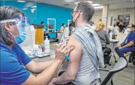  ?? L.E. Baskow Las Vegas Review-journal @Left_eye_images ?? Nurse Noel Madic injects University Medical Center resident physician Austin Christians­en as front-line health care workers receive their Pfizer vaccine on Dec. 16.